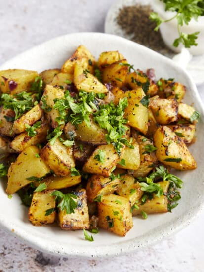A platter of air fryer golden potatoes topped with parsley.