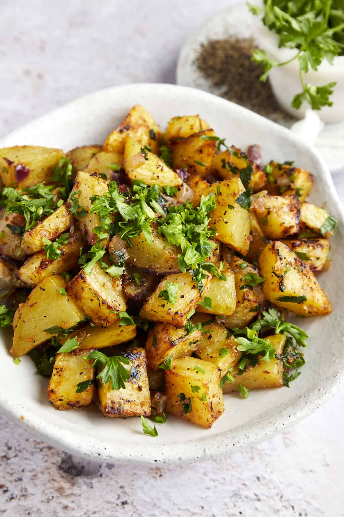 A platter of air fryer golden potatoes topped with fresh parsley. 