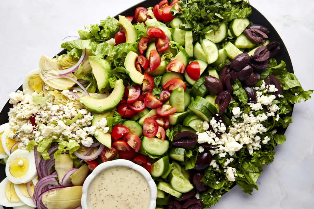 Middle Eastern Cobb Salad with a container of dressing on the side.