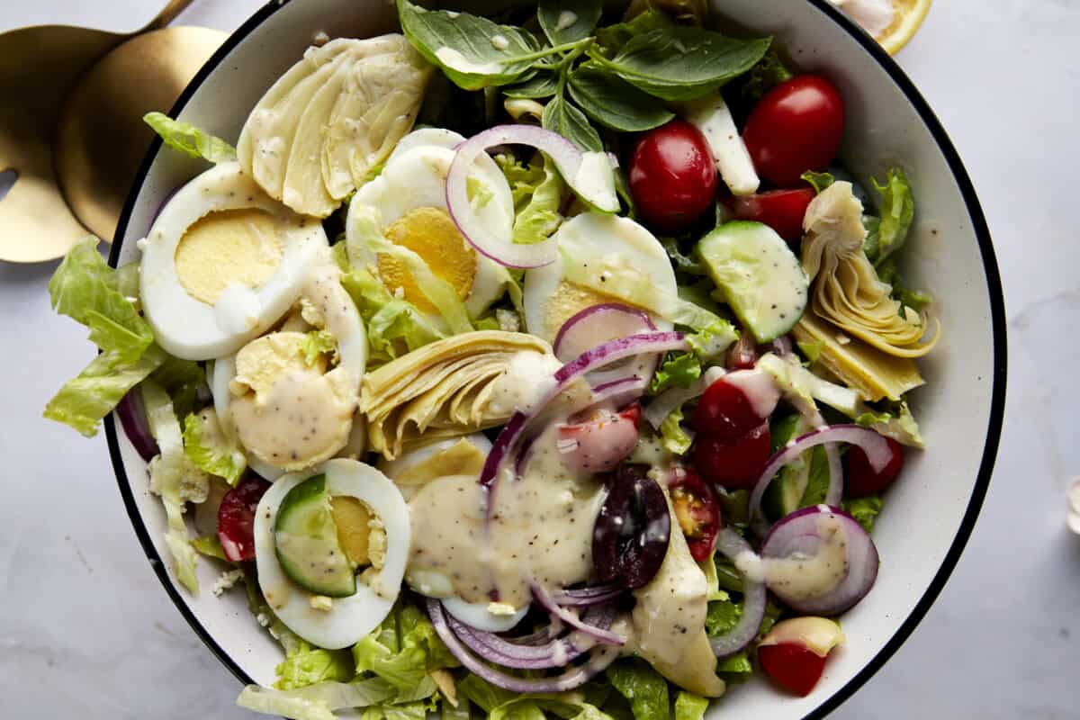 A bowl of Middle Eastern Cobb Salad topped with dressing. 