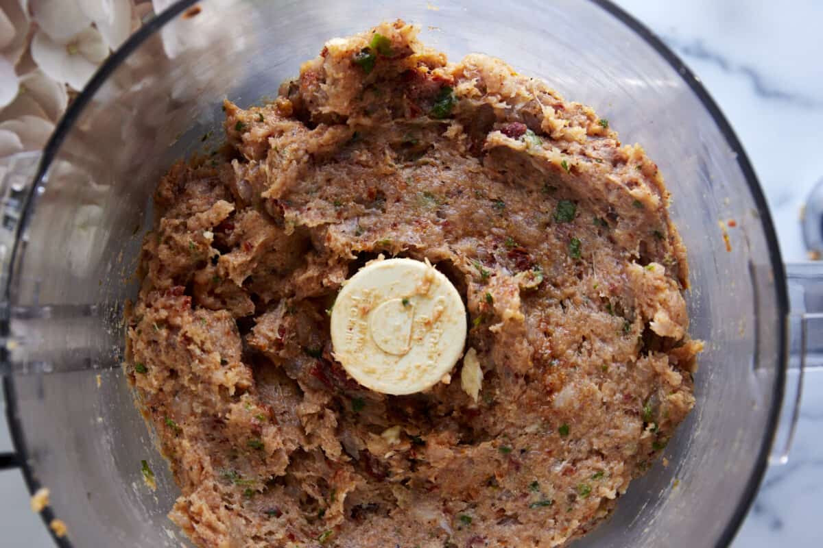 Raw chicken meatball mixture in a food processor. 