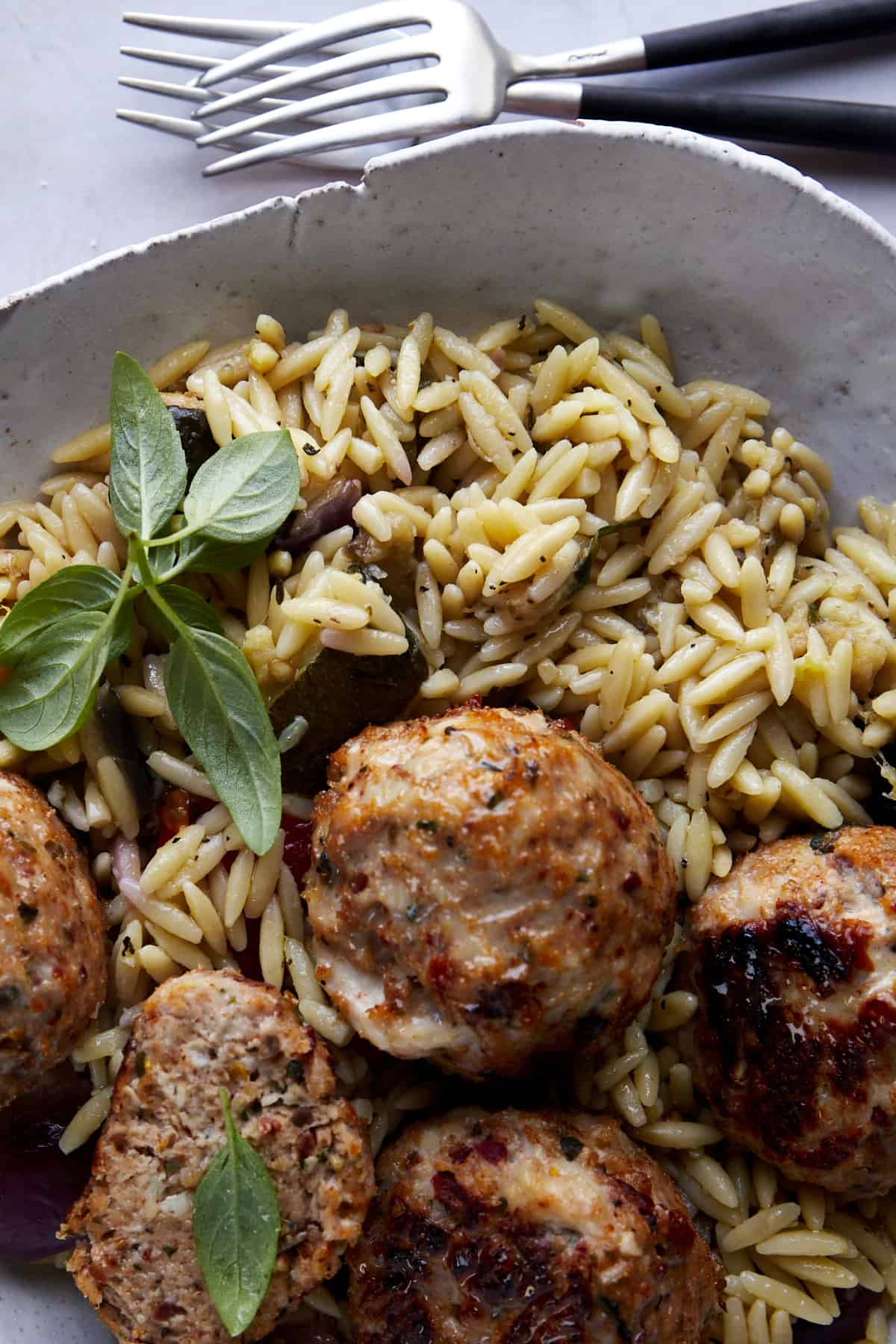 Close up image of sun-dried tomato chicken meatballs over rice. 