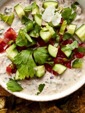 Overhead image of a bowl of tahini salad with pita chips.