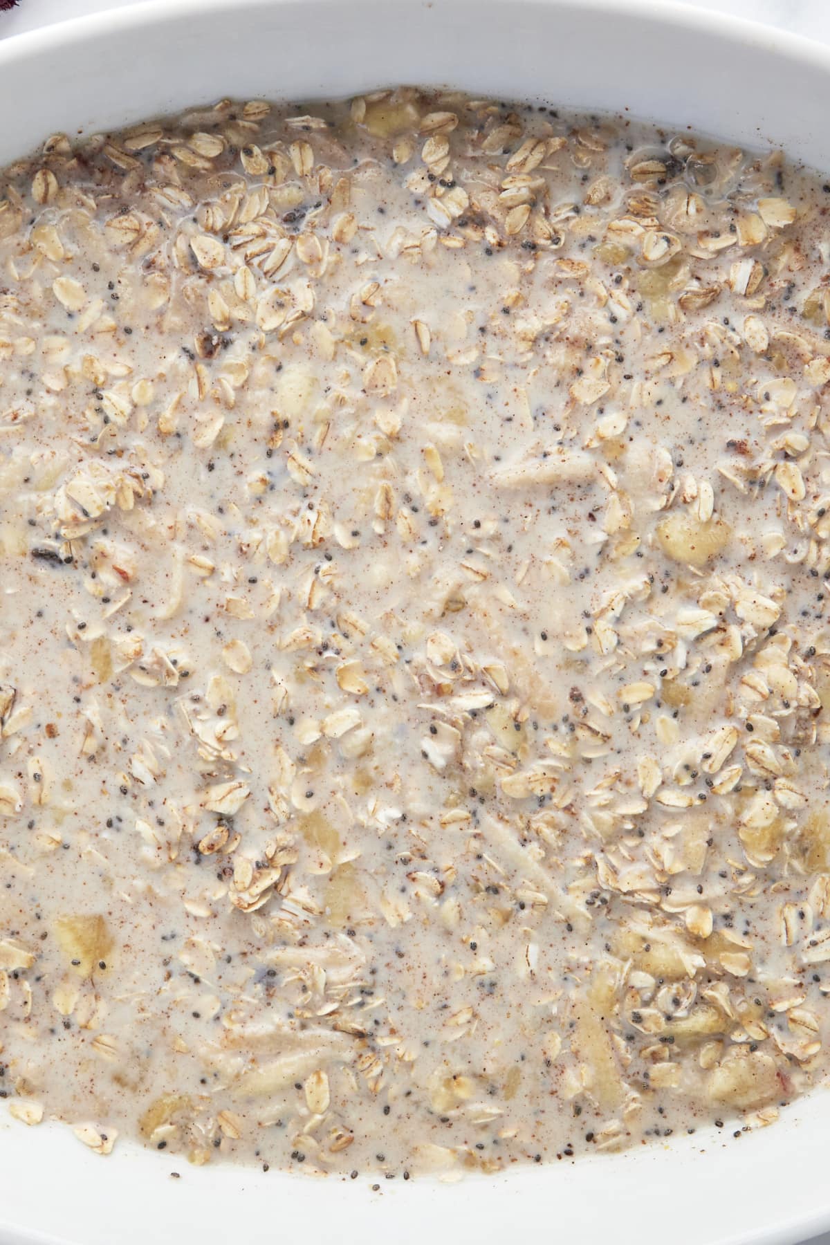 Unbaked ingredients for baked apple oatmeal in a baking dish. 