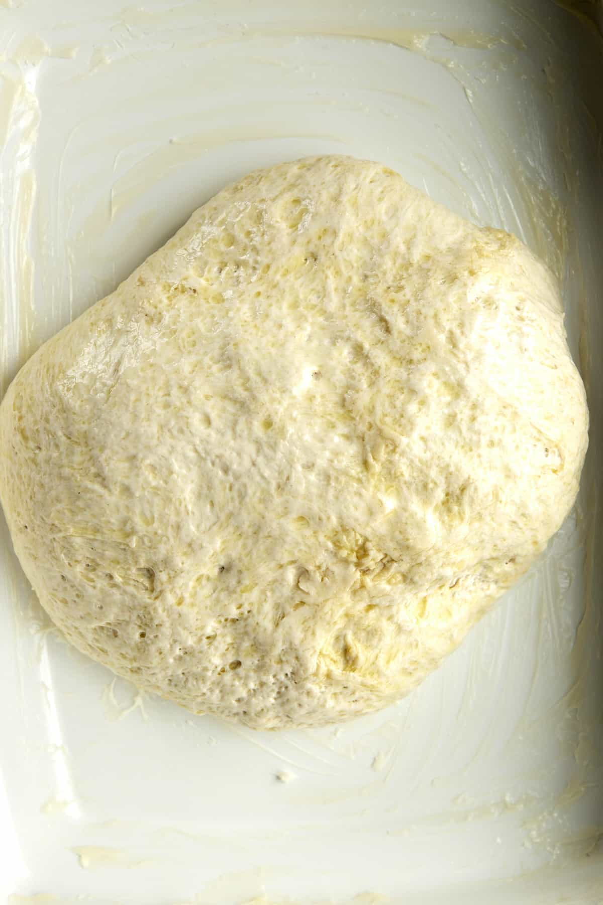 Overhead image of a ball of dough in a baking dish.