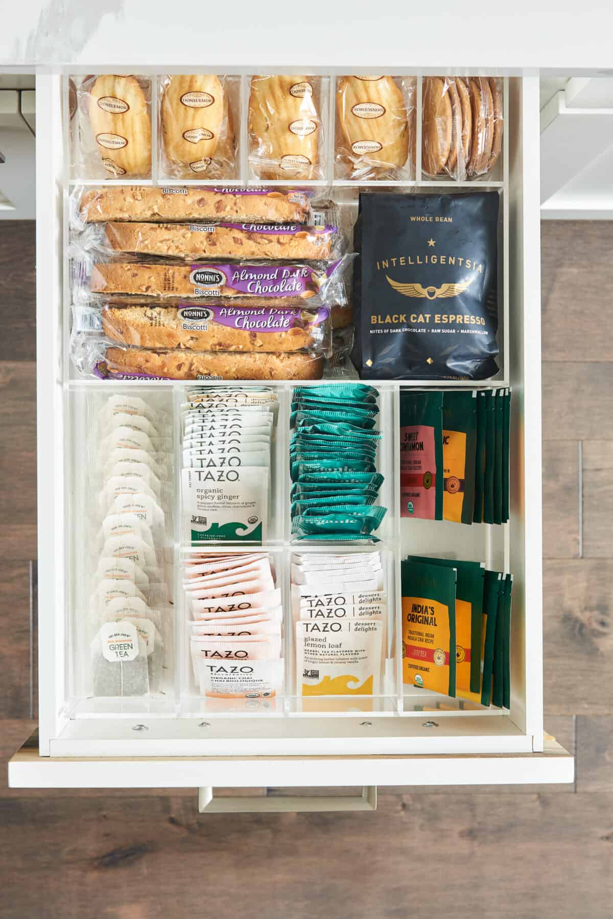 inside of drawer with storage holding tea, coffee, and snacks.