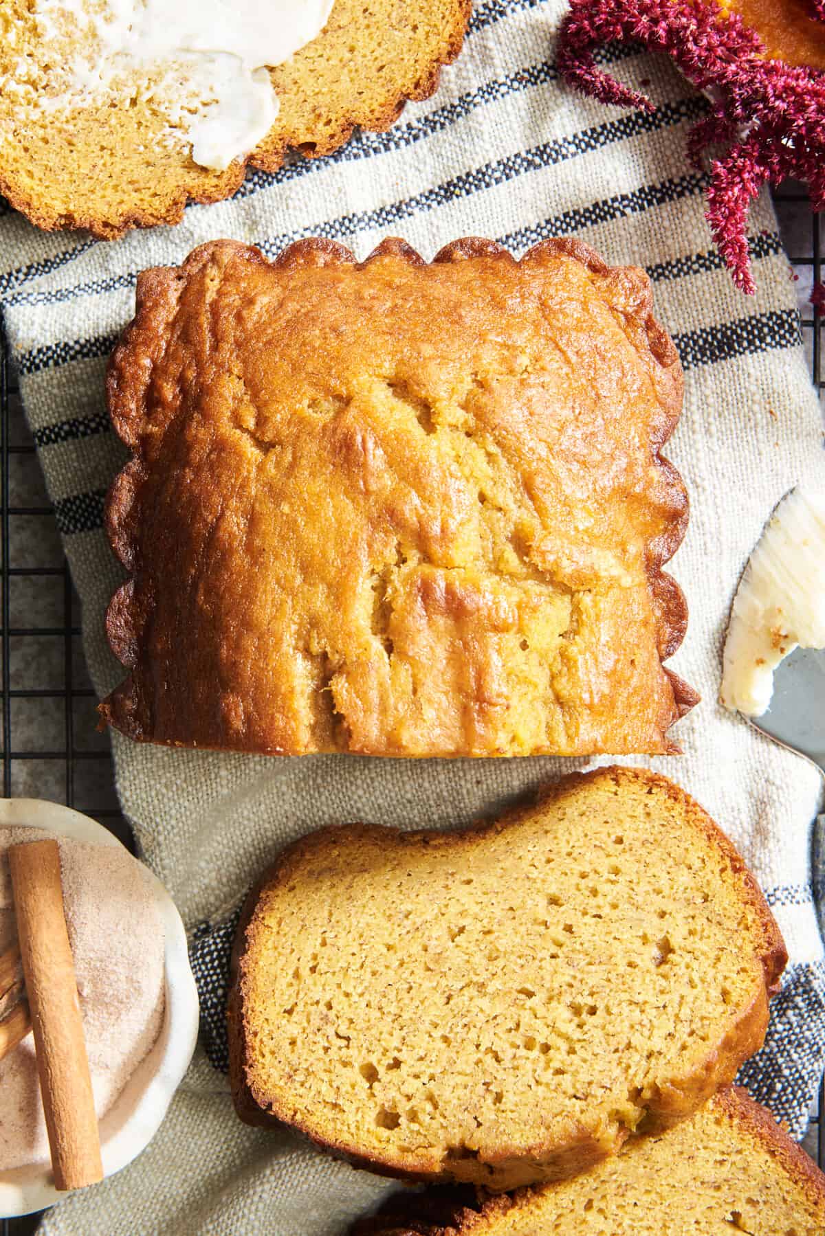 A loaf of pumpkin banana bread with a few slices cut off. 