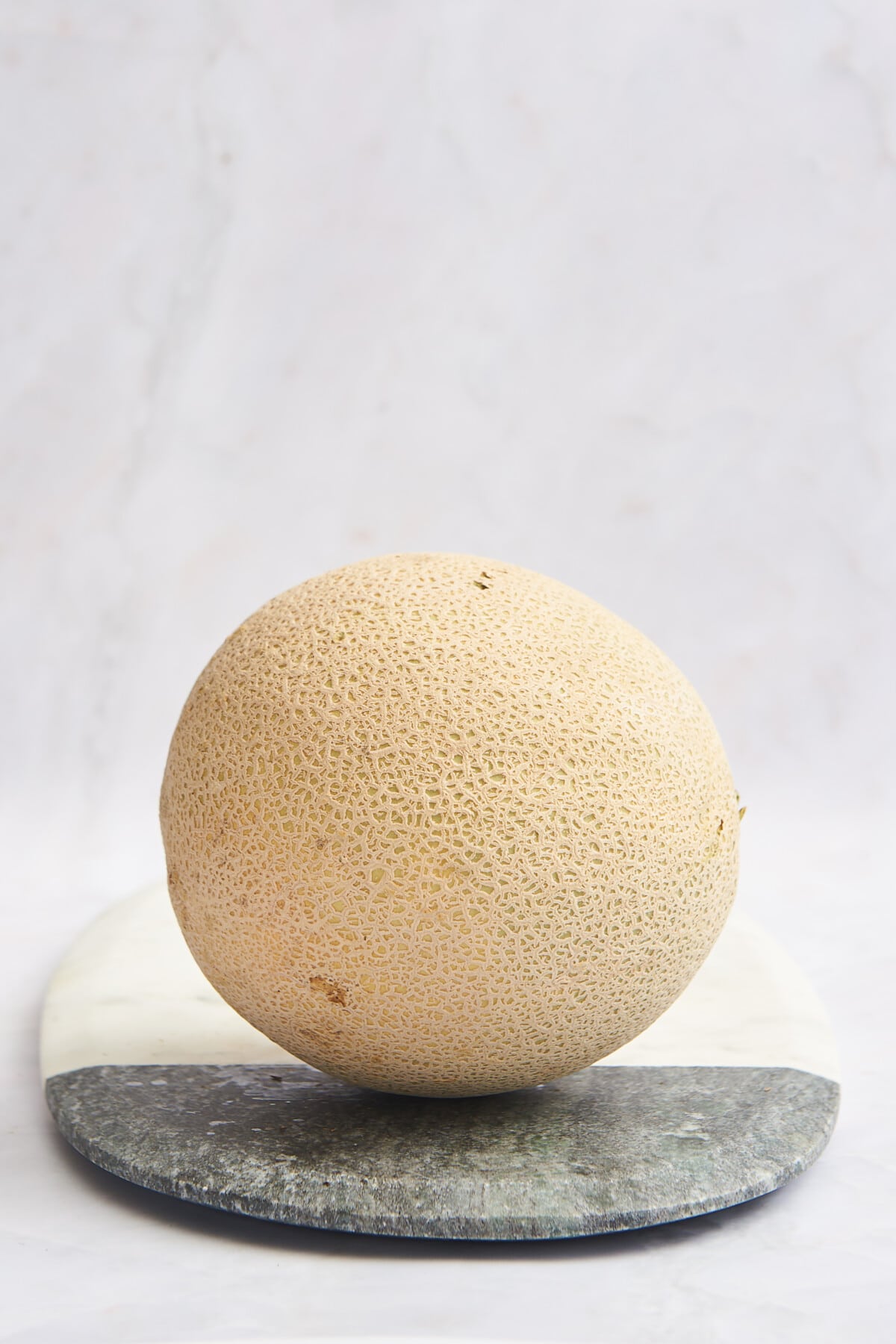 A cantaloupe on a cutting board. 