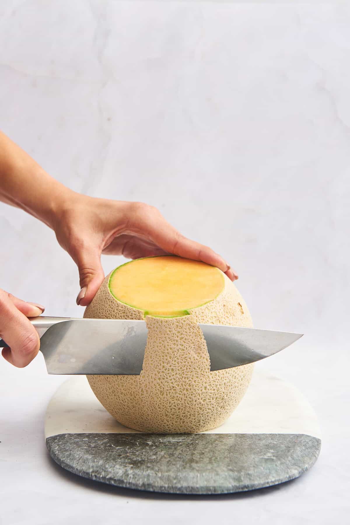 The skin being removed from a cantaloupe. 