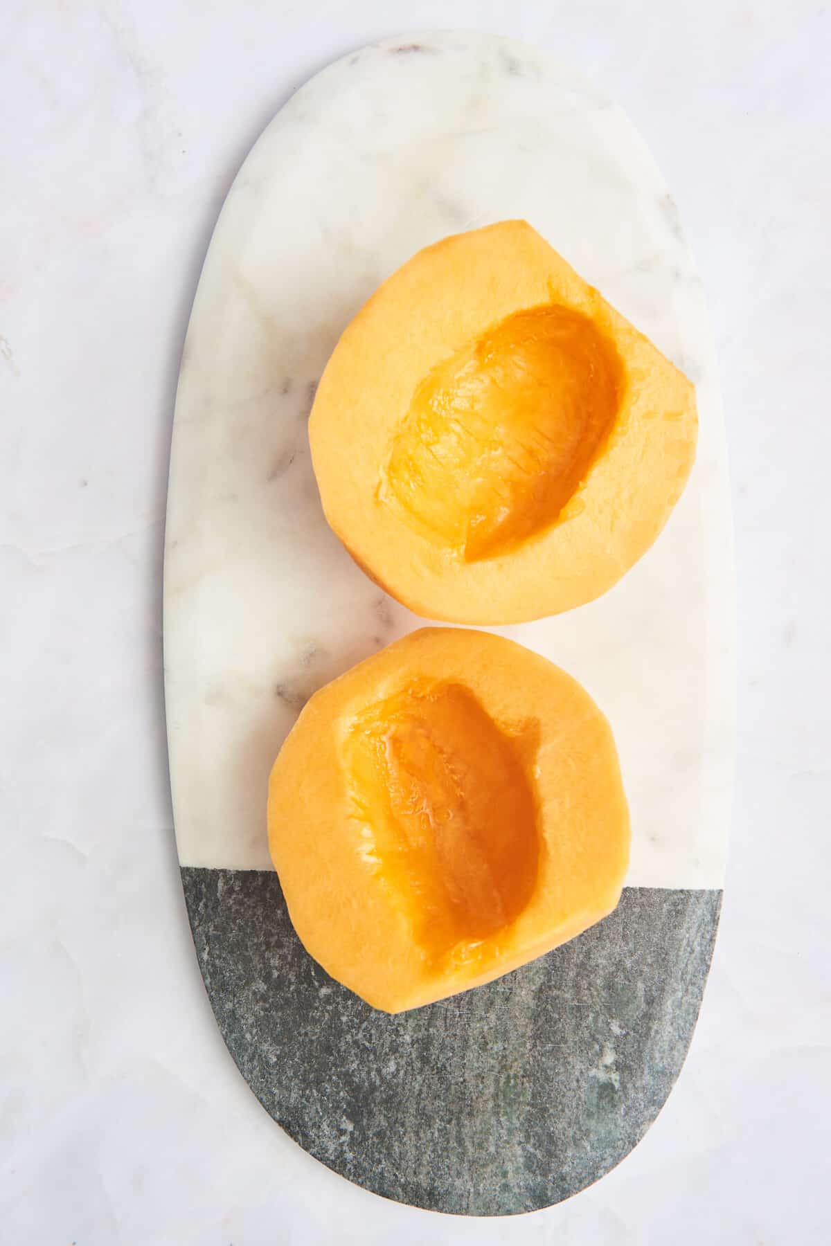 Overhead image of two halves of a cantaloupe fruit. 