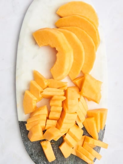 A platter of sliced cantaloupe slices and cubes.