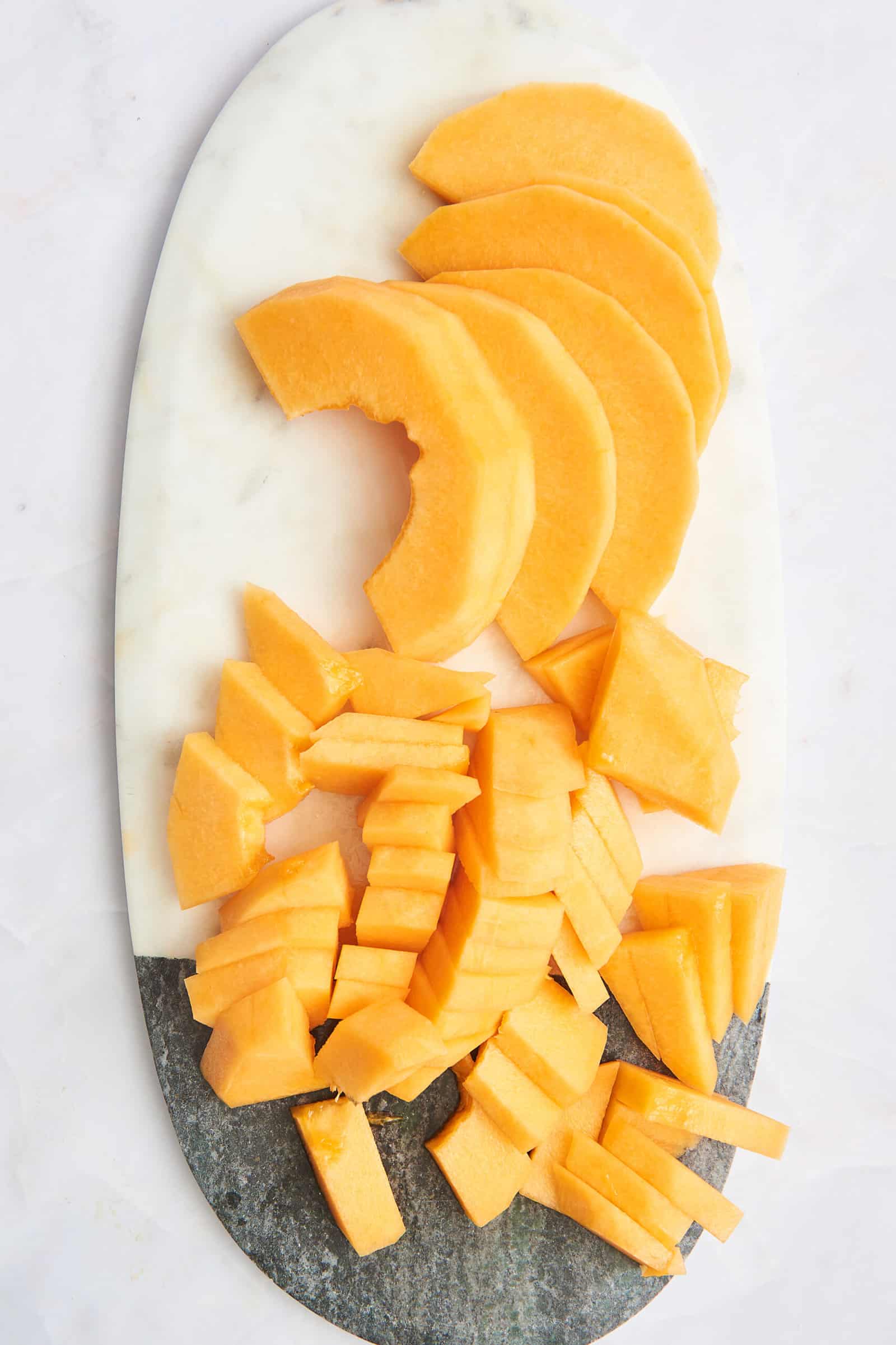 A platter of sliced cantaloupe slices and cubes.
