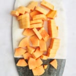 Pieces of papaya on a cutting board.