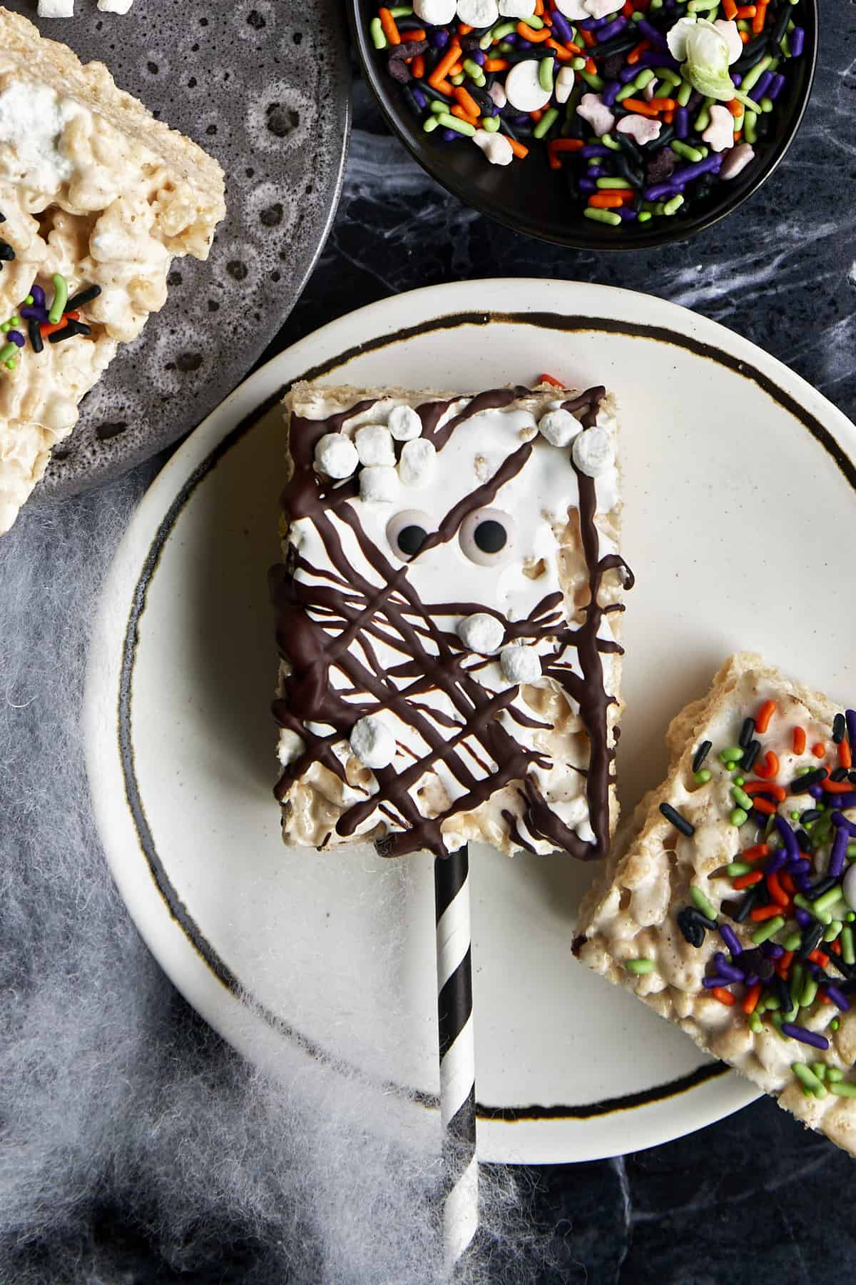 A Halloween rice krispie treat topped with chocolate, marshmallows, and candy eyes. 