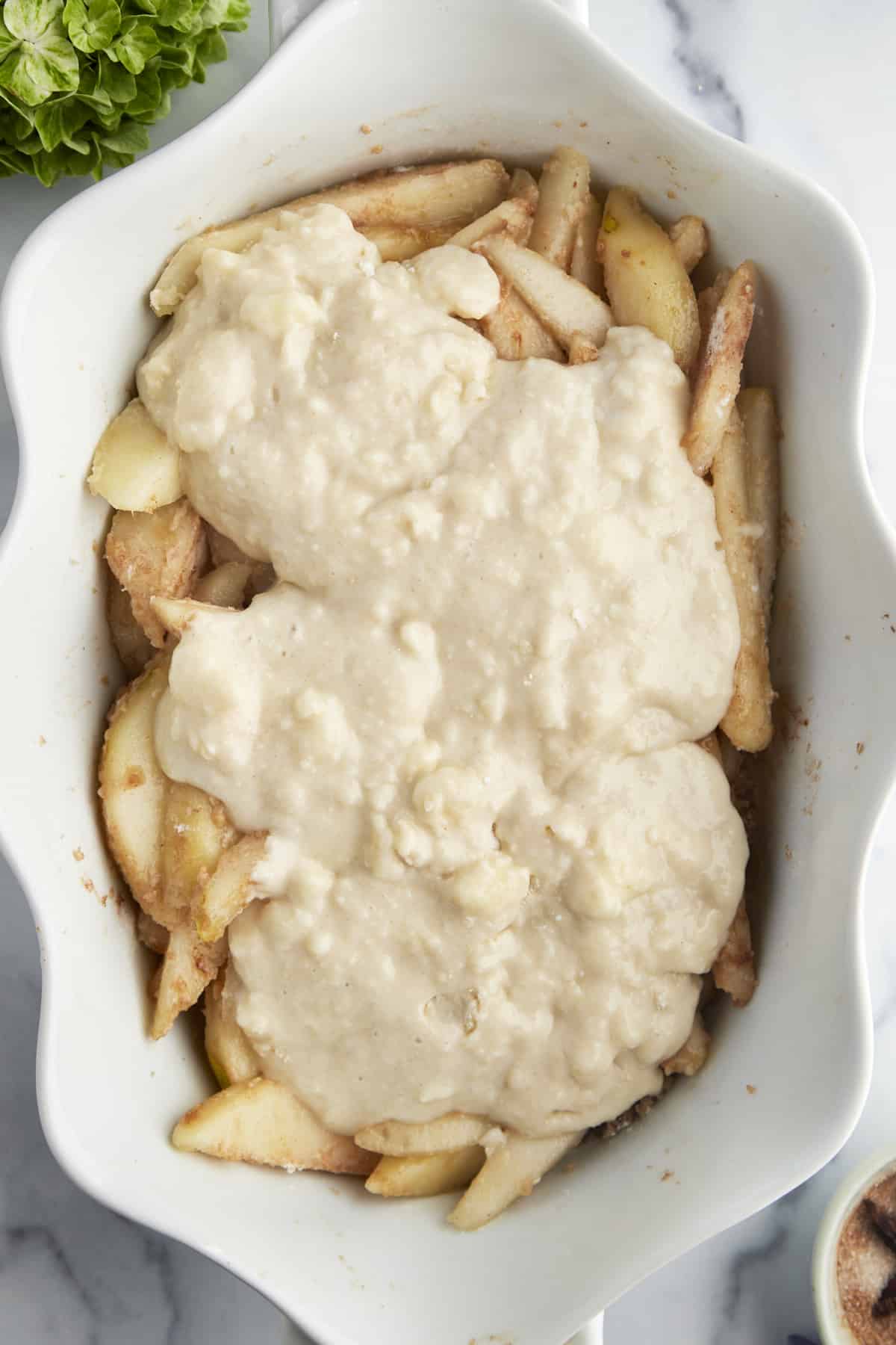 Unbaked pear cobbler in a baking dish. 