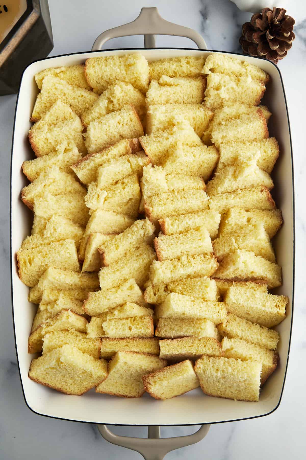 Bread pieces in a single layer in a baking dish. 
