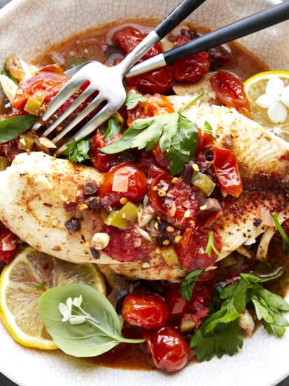 A bowl of Mediterranean tilapia with two forks.