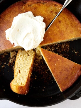 A skillet of brown butter cornbread topped with whipped butter.