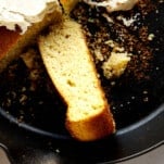 A piece of brown butter cornbread on its side in a skillet.
