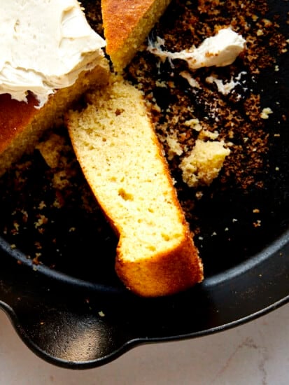 A piece of brown butter cornbread on its side in a skillet.