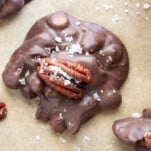 A chocolate caramel pecan cluster topped with a pecan and salt.