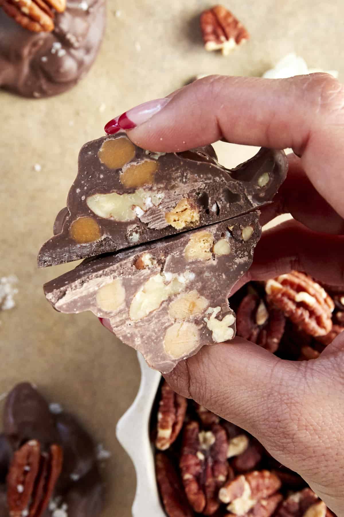 Two halves of a caramel pecan cluster.