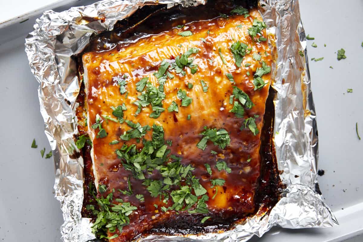 Baked honey garlic salmon topped with cilantro in a foil packet. 