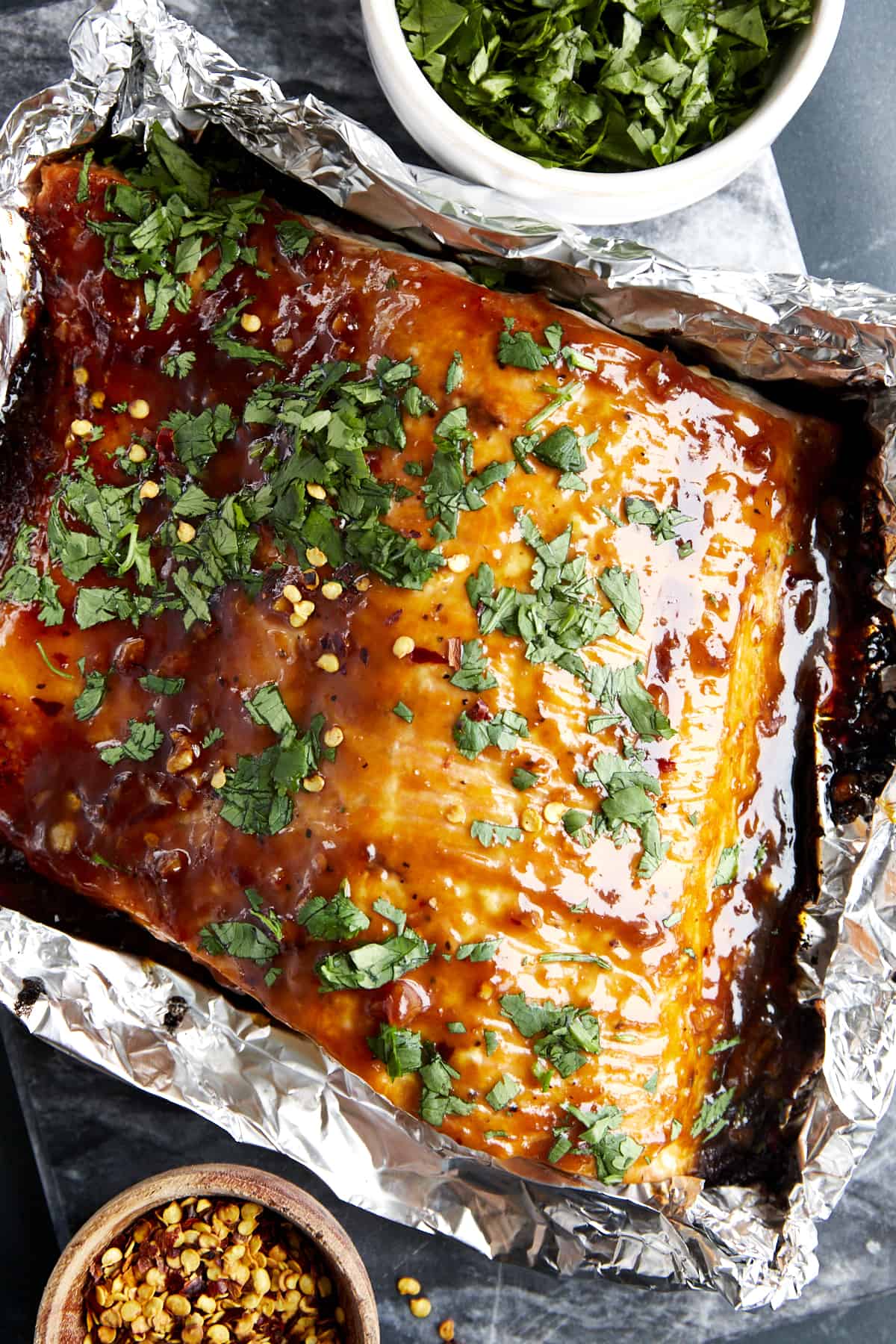 Baked honey garlic salmon topped with fresh cilantro in a foil packet.