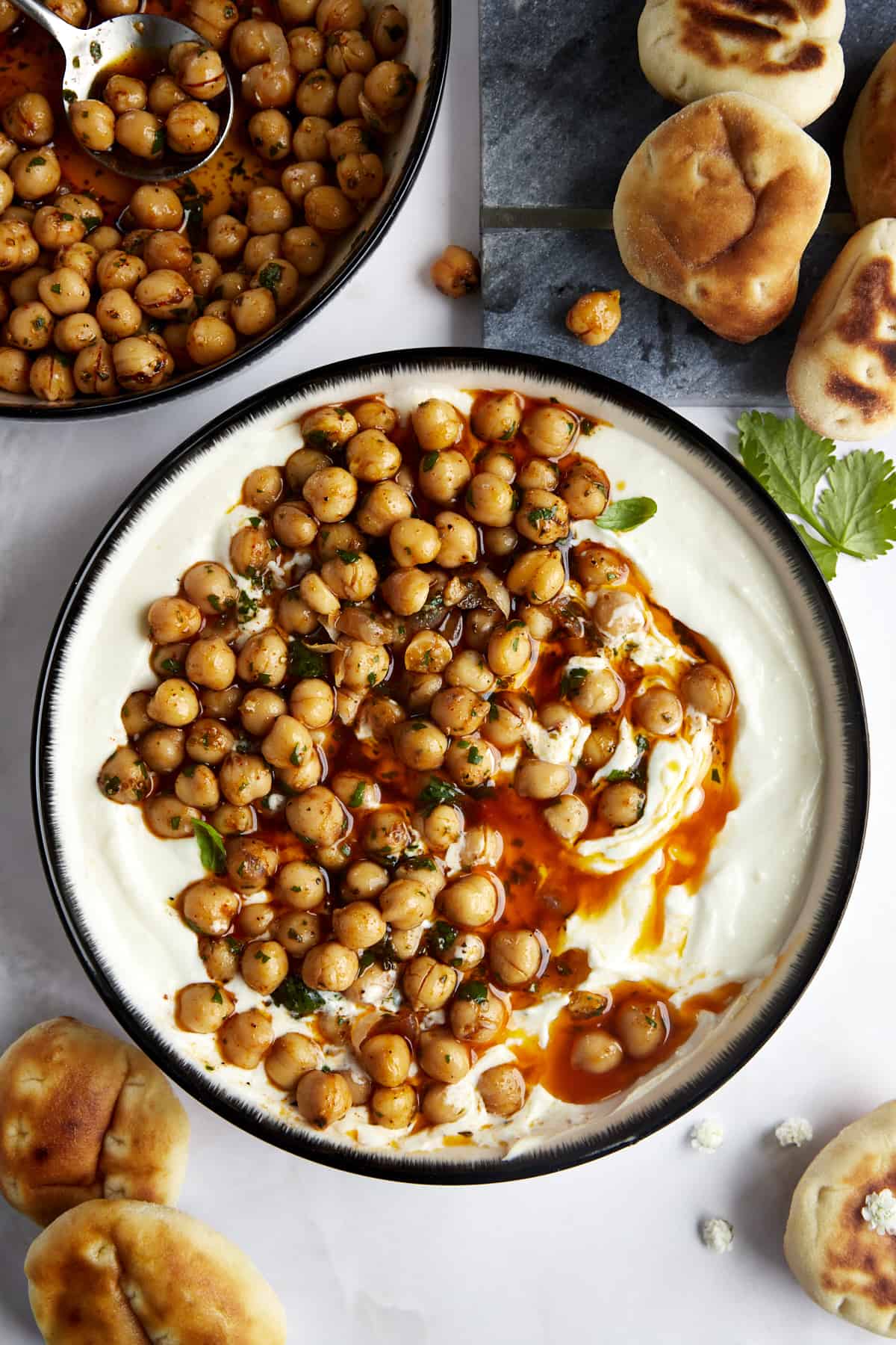 A bowl of marinated chickpeas over whipped feta. 