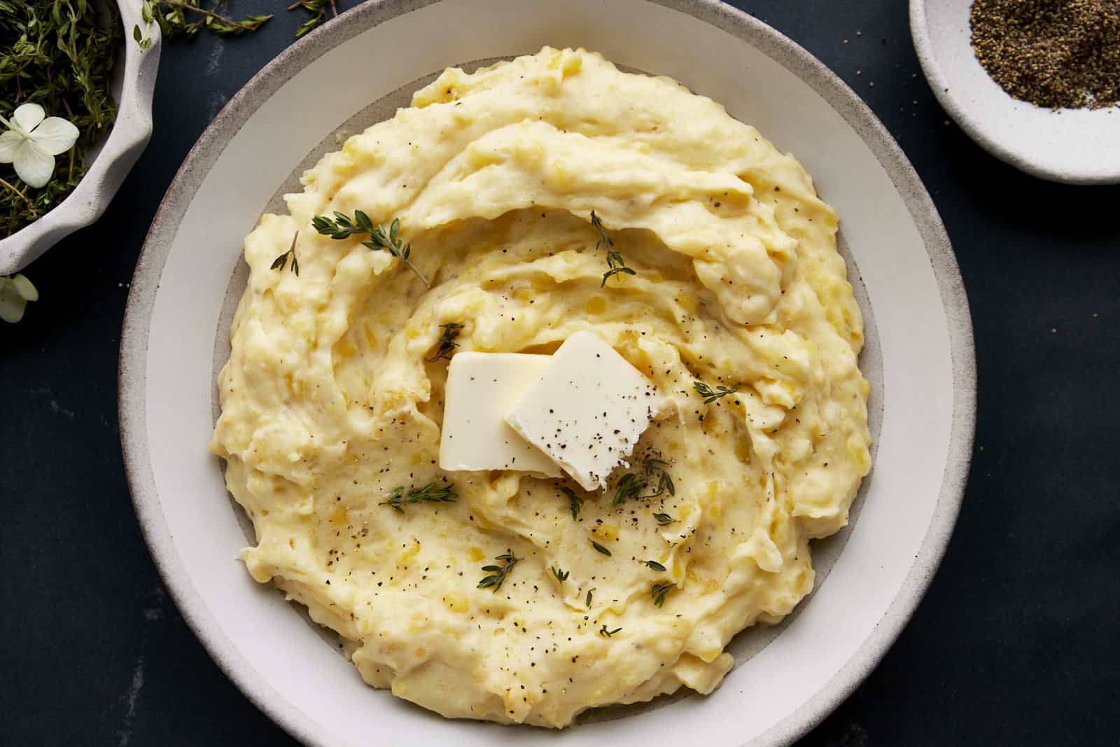 A bowl of the best mashed potatoes recipe topped with pads of butter.