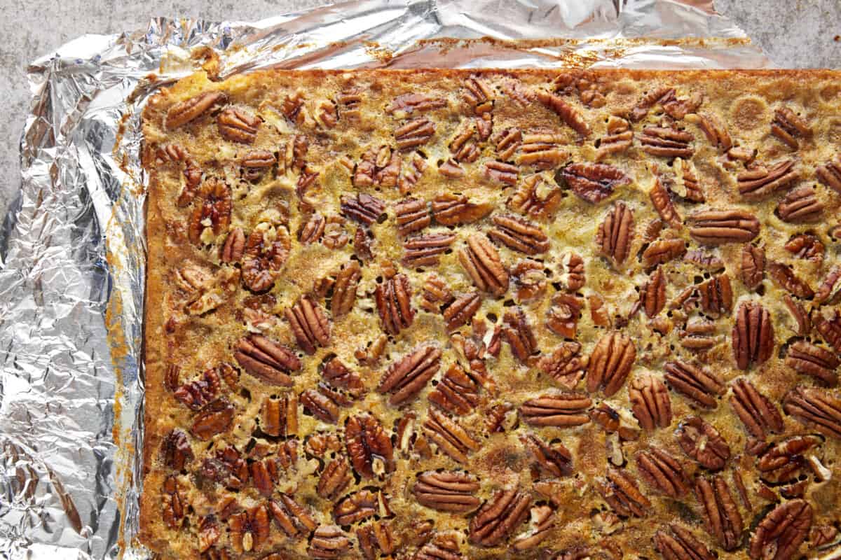 A slab of easy pecan pie bars on top of aluminum foil. 