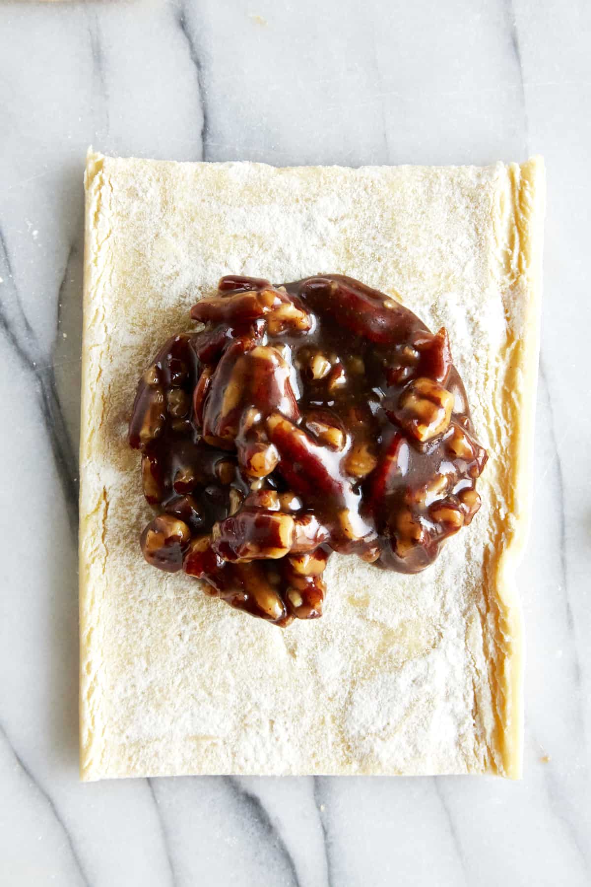 Pecan pie filling in the center of a puff pastry square. 