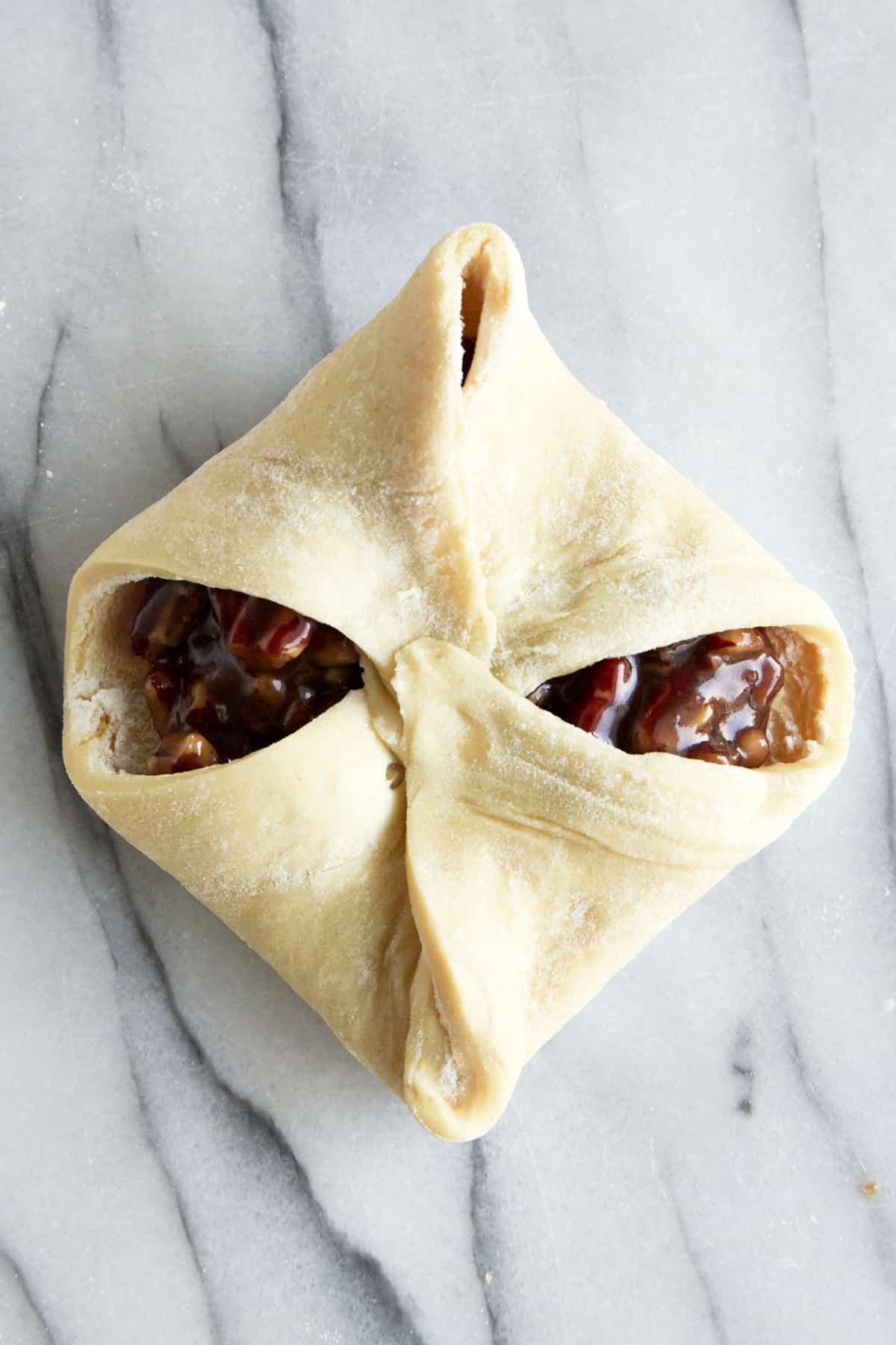 An unbaked pecan pie puff pastry bite. 