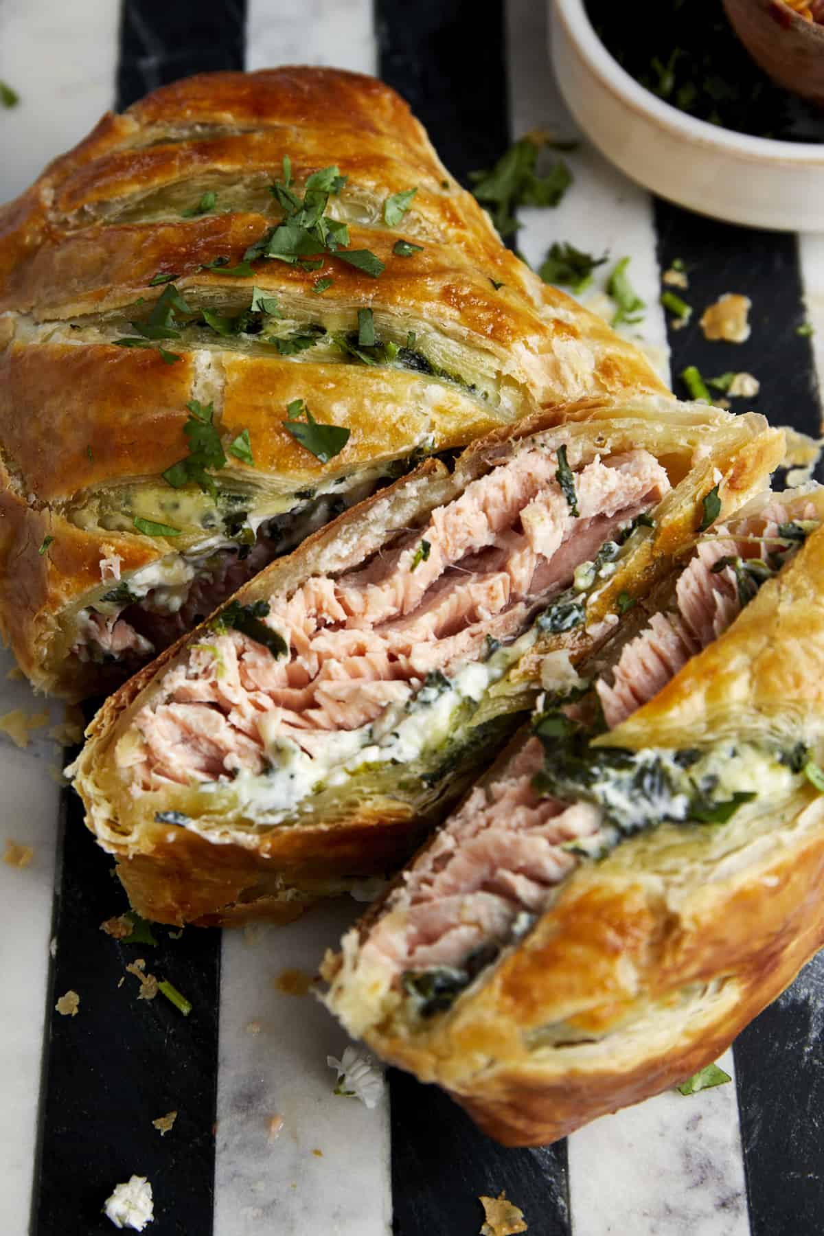 Salmon Wellington with two servings sliced exposing the interior. 