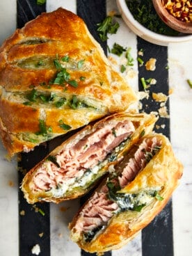 Salmon Wellington with two pieces sliced exposing the interior.