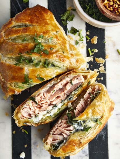 Salmon Wellington with two pieces sliced exposing the interior.