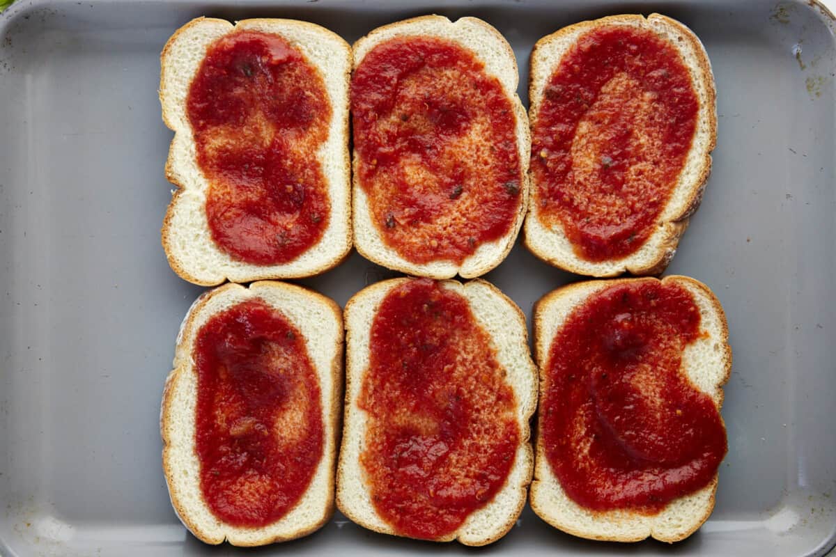 Marinara spread over six pieces of bread. 