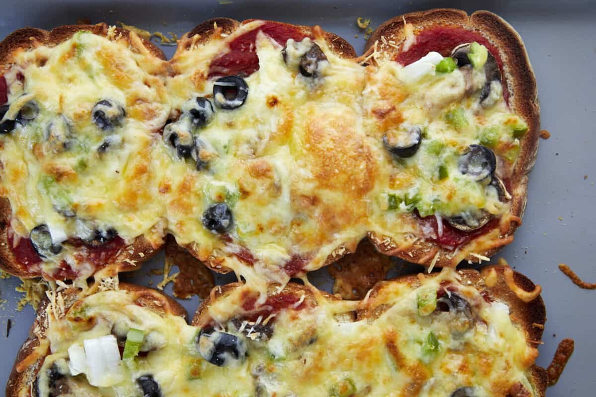 Baked sheet pan pizza made with bread pieces on a baking sheet. 