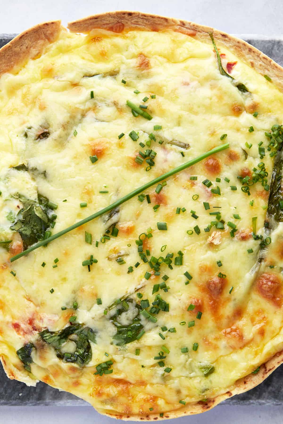Close up view of an egg tortilla bake topped with fresh herbs. 