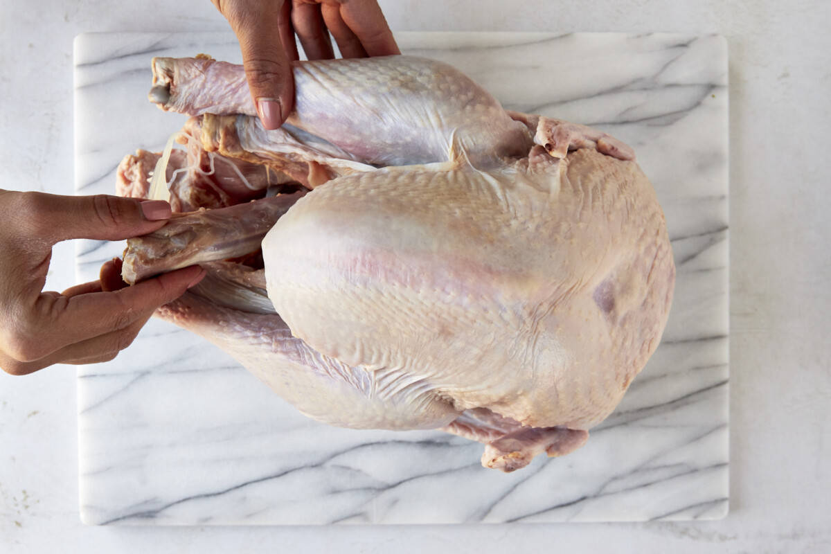 The neck and giblets being removed from a raw turkey. 