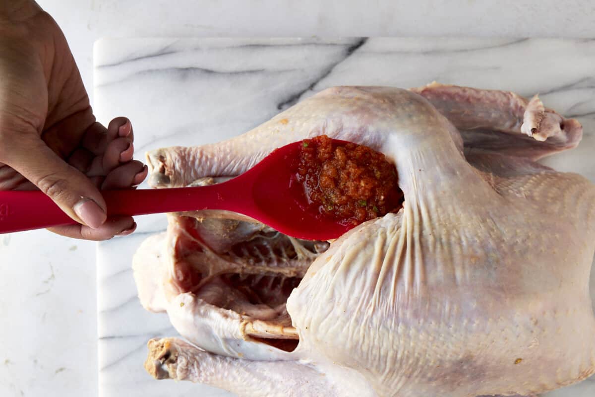 Turkey brine being spread under turkey skin. 