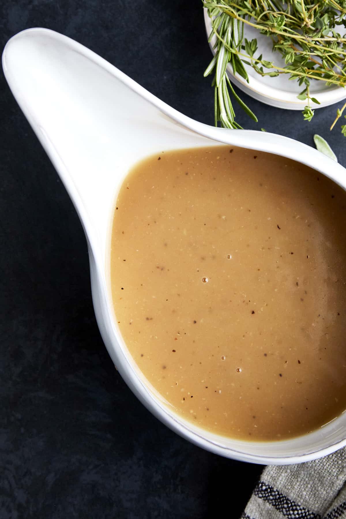 A white turkey boat full of homemade turkey gravy. 