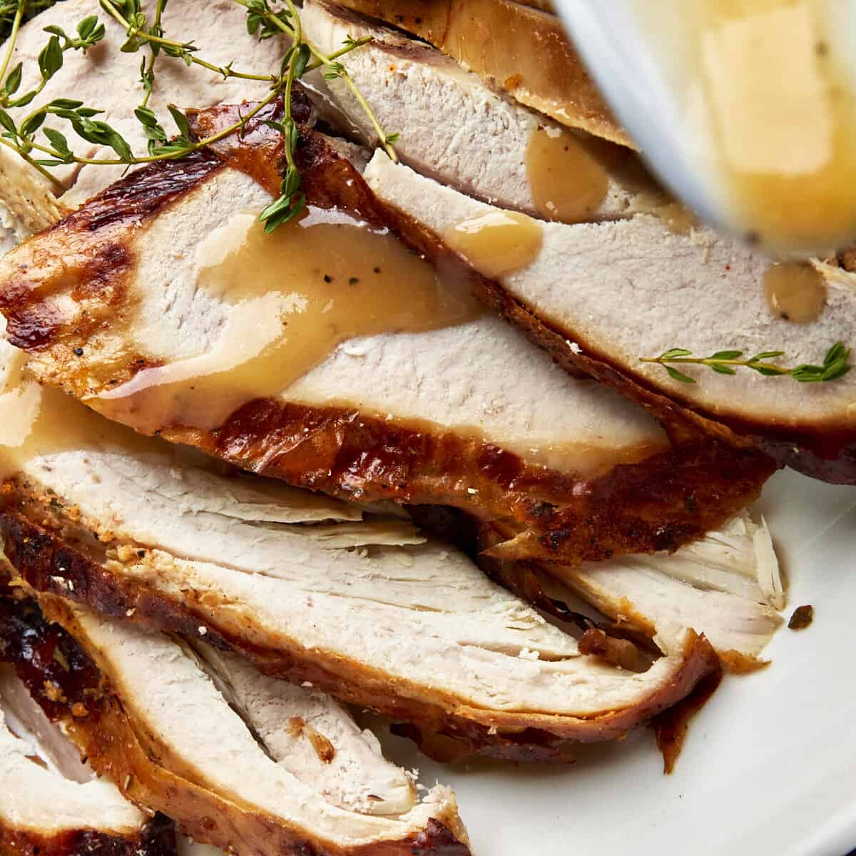 Sliced turkey with gravy drizzled on top.