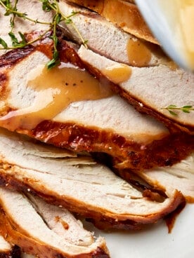 Sliced turkey with gravy drizzled on top.