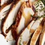Slices of baked turkey drizzled with turkey gravy.