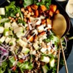 A bowl of sweet potato salad with chickpeas topped with tahini dressing.