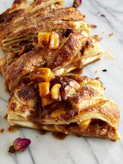 An apple puff pastry sliced into four pieces.