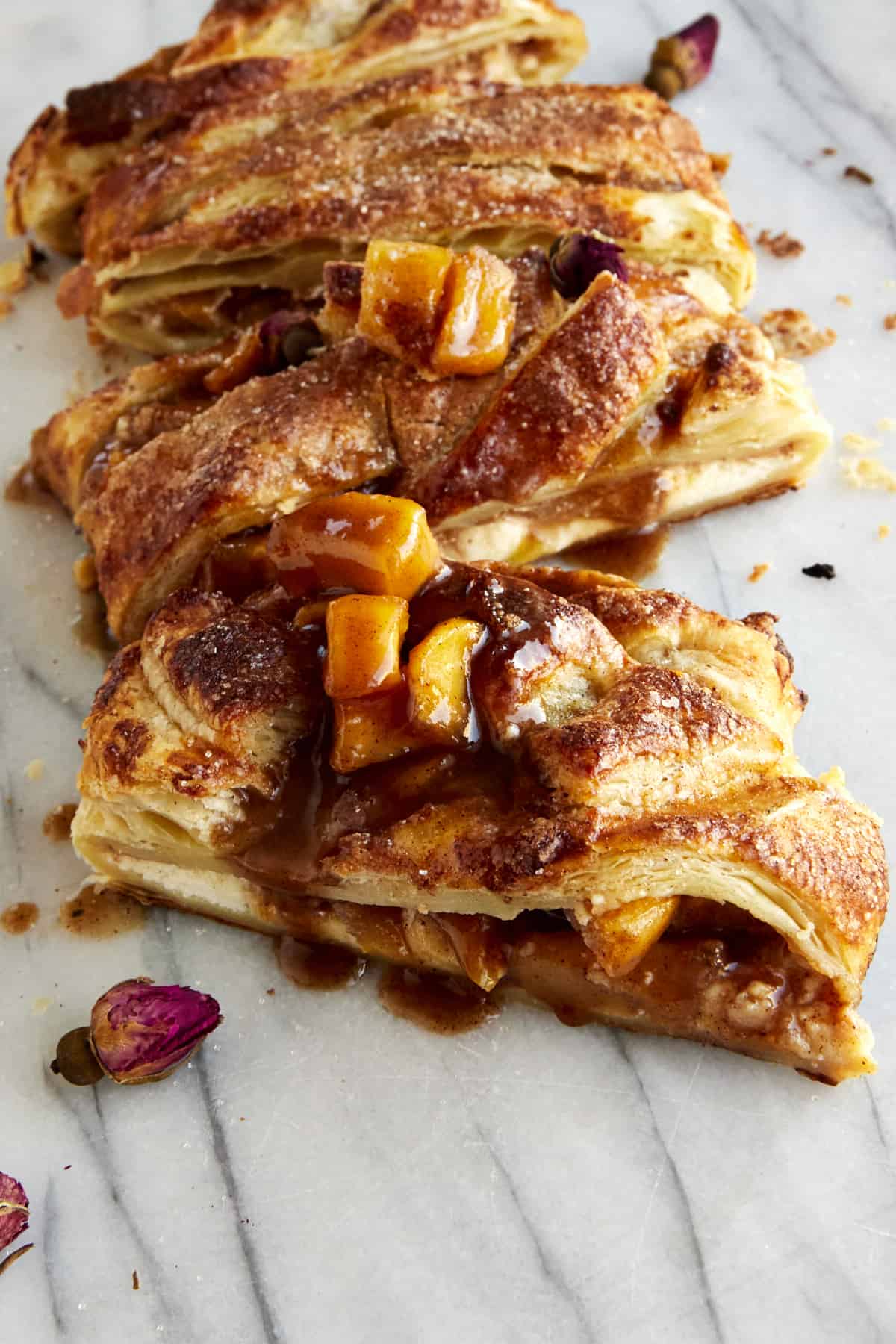 A baked apple puff pastry braid sliced into pieces.