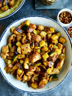 A bowl of chicken and zucchini stir fry.