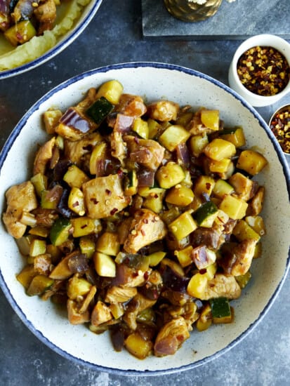 A bowl of chicken and zucchini stir fry.